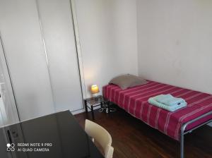 ein kleines Zimmer mit einem Bett, einem Tisch und einem Stuhl in der Unterkunft Superbe F3 dans résidence calme, in Nancy