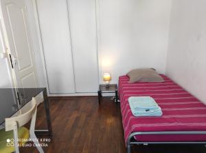 ein kleines Zimmer mit einem Bett mit einer rosa Decke in der Unterkunft Superbe F3 dans résidence calme, in Nancy