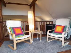 zwei Stühle und ein Tisch in einem Raum in der Unterkunft Horseshoe Cottage Aberaeron in Ciliau-Aeron