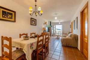 a dining room and living room with a table and chairs at Casa Los Compadres de Capileira con Piscina in Capileira