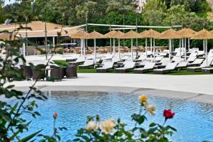 una piscina con sedie e tavoli e un resort di Salles Hotels Marina Portals a Portals Nous