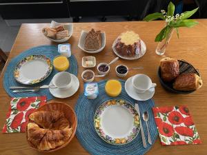 un tavolo con piatti di cibo e pane sopra di La Chambre Claire a Ponts-et-Marais