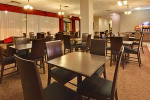 a dining room with tables and chairs in a restaurant at Holiday Inn Express Los Angeles LAX Airport, an IHG Hotel in Los Angeles