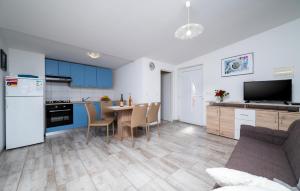 una cocina con armarios azules y una mesa con sillas en Lovely Apartment In Kavran With Wifi, en Kavran
