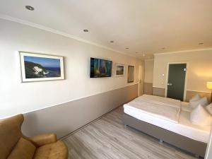 ein Schlafzimmer mit einem Bett und einem Sofa darin in der Unterkunft Hotel zum Hafen in Sassnitz