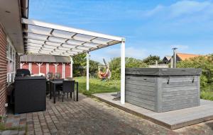 a patio with a table and a white pergola at Gorgeous Home In Skagen With Wifi in Skagen