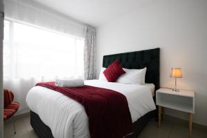 a bedroom with a large bed with a red blanket at Safi Smart Self-catering Suite 1 in East London