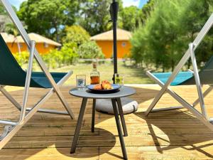 a table with a plate of food and two chairs at Bungalow Agathe - Piscine, Wifi, Farnienté et Plage à 2 minutes in Grand-Bourg