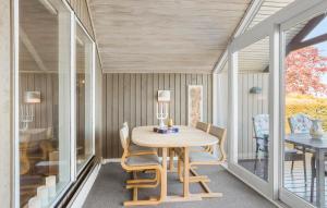 a dining room with a wooden table and chairs at Holiday Home Træløbervej Tranekær Denm in Lokkeby +10 photos