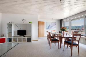 comedor con mesa, sillas y TV en Ferienwohnung Lange, en Waldstetten