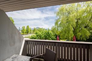 einen Balkon mit einem Tisch, Stühlen und Bäumen in der Unterkunft Salzburg Hotel Lilienhof in Salzburg