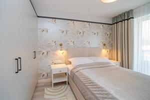 ein Schlafzimmer mit einem Bett und einer Wand mit Vögeln in der Unterkunft APARTAMENT Ceynowa in Karthaus