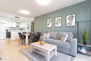 a living room with a couch and a table at Pura Vida Beach Apartment by Perfectly Rentals in Torrevieja