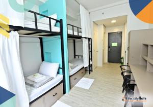 a dorm room with two bunk beds and a hallway at The City Flats Sacred Heart in Manila