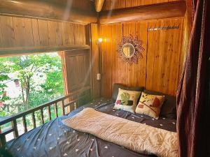 Cama en habitación de madera con ventana en Pea homestay, en Sa Pa