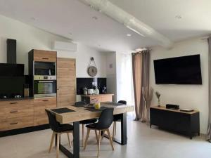 a living room with a table and chairs and a television at Villa charmante à Châteaurenard avec piscine privée in Châteaurenard +3 photos