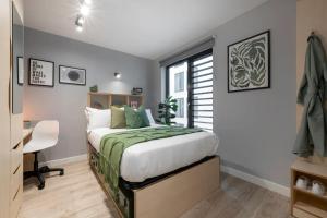 a bedroom with a bed and a desk and a window at Cosy and Chic Private Ensuites at Alma Place in the heart of Belfast in Belfast