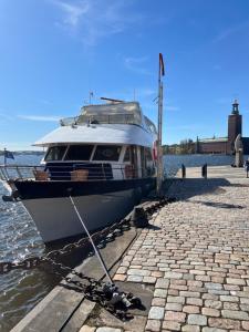 a boat is tied up to a dock at Mälardrottningen Yacht Hotel in Stockholm