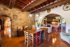 Podere a La Fi في شيتونا: مطبخ مفتوح وغرفة طعام مع طاولة وكراسي خشبية