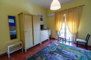 una camera con letto, armadio e sedie di B&B Musìa a Milazzo