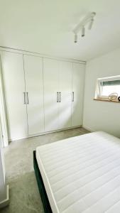 a white bedroom with a bed and white cabinets at Apartamenty Skwierzyna in Skwierzyna