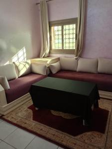 uma sala de estar com um sofá e uma janela em Riad Nasma Souihla em Marrakech
