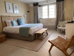 Ogygia Suites Gozo في غرب: غرفة نوم بسرير وطاولة وكرسي