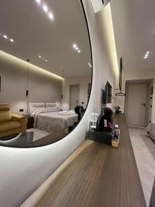 Holiday House في نابولي: غرفة نوم مع مرآة دائرية كبيرة على الحائط