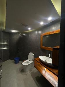 a bathroom with a toilet and a sink at Tilagaon Eco Village in Sreemangal
