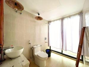 ein Bad mit einem WC, einem Waschbecken und einem Fenster in der Unterkunft Tilagaon Eco Village in Sreemangal