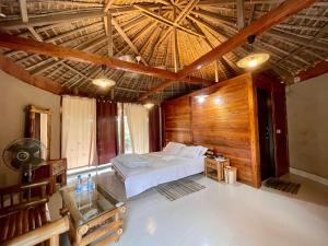 a bedroom with a bed and a wooden ceiling at Tilagaon Eco Village in Sreemangal