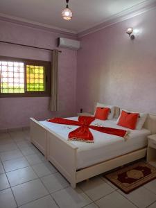 a bedroom with a bed with a red bow on it at Riad Nasma Souihla in Marrakesh