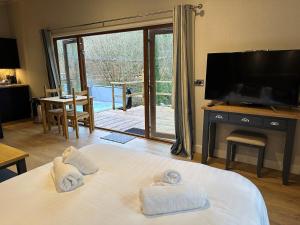 CaerwysにあるHerons Lake Retreat Lodgesのベッド1台(タオル付)が備わる客室です。