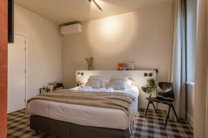 um quarto com uma cama grande com lençóis brancos e almofadas em WAY SWEET DREAMS - Room 2 em Gent