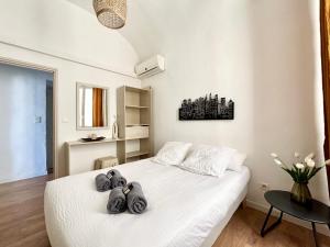um quarto com uma cama branca com três toalhas em Grand T2 - Centre ville -10 min de la plage à pied em Ajaccio