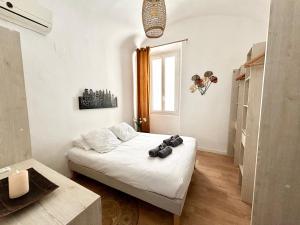 um quarto com uma cama branca e uma janela em Grand T2 - Centre ville -10 min de la plage à pied em Ajaccio