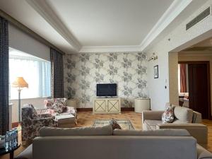 فندق غراند أوروبا في باكو: غرفة معيشة مع كنب وتلفزيون بشاشة مسطحة
