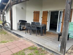 a patio with a table and chairs on a porch at chalet T4 ondres piscine et tennis in Ondres