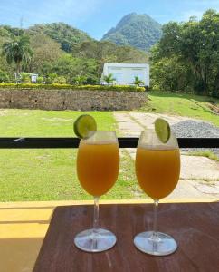 two glasses of orange juice on a table with a view at Eco Hotel Montenegro in Medellín
