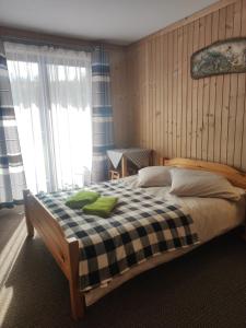 a bedroom with a bed with a checkered blanket at U Wajdy in Małe Ciche