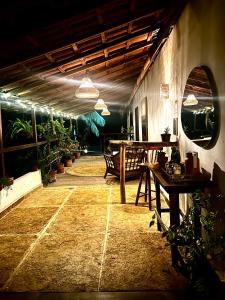 eine Terrasse mit Tischen und Topfpflanzen in einem Gebäude in der Unterkunft Jandaia Atins in Atins