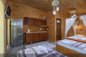 a room with two beds and a kitchen with a refrigerator at Flora Pansiyon Çıralı in Kemer