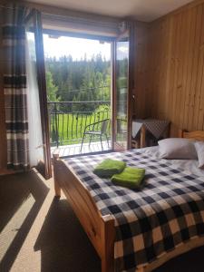 a bedroom with a bed and a large window at U Wajdy in Małe Ciche