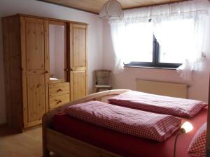 een slaapkamer met een bed, een kast en een raam bij Übernachten im Café Restaurant Vedder in Herscheid
