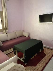 uma sala de estar com um sofá e uma mesa em Riad Nasma Souihla em Marrakech