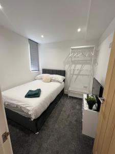 een slaapkamer met een groot bed en een televisie bij The Grange in Birkenhead