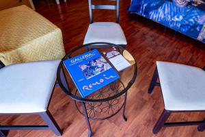 un tavolo con un libro sopra accanto a due sedie di B&B Musìa a Milazzo