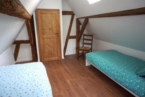 Schlafzimmer mit einem Bett und Holzboden in der Unterkunft Gîte Les Hirondelles - maison typique - centre village - proche vignoble in Scherwiller