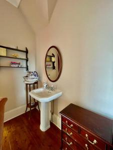 a bathroom with a sink and a mirror at TORWOOD VICTORIAN HOUSE in Ventnor