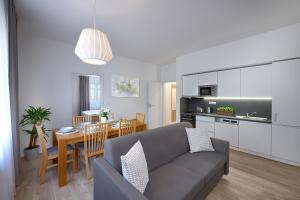 a living room and kitchen with a couch and a table at DownTown Suites Belohorska in Prague
